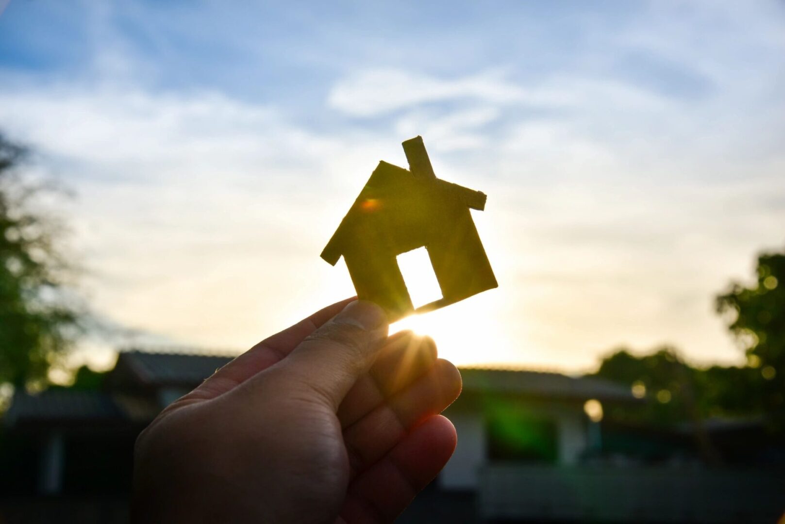 qtq80-jHydqJ Silhouette of a house against a sunrise illustrating the right time to buy or build a new house.
