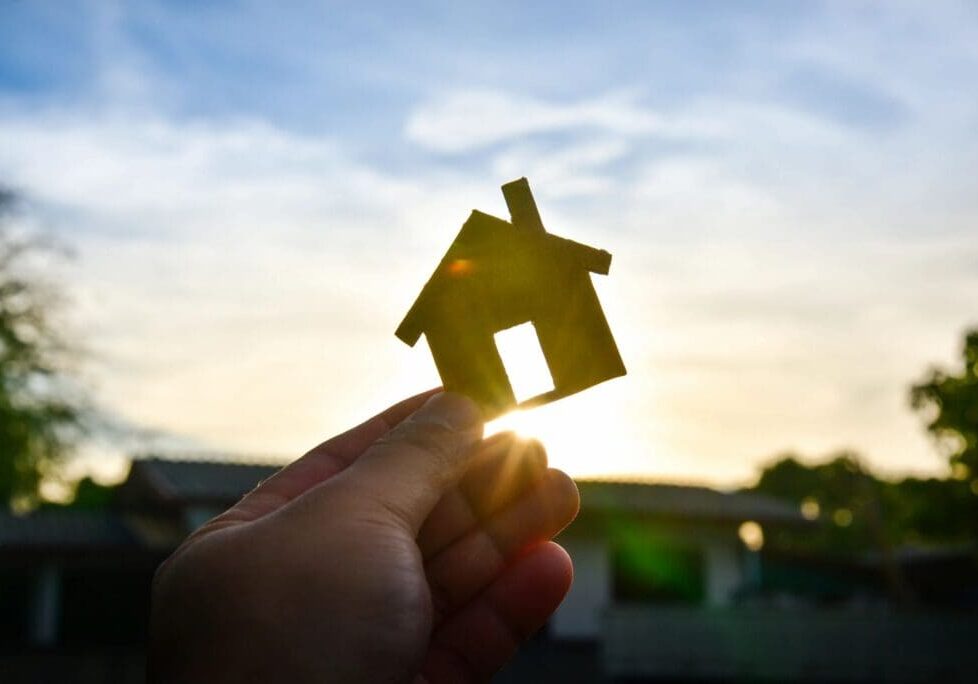 qtq80-jHydqJ Silhouette of a house against a sunrise illustrating the right time to buy or build a new house.